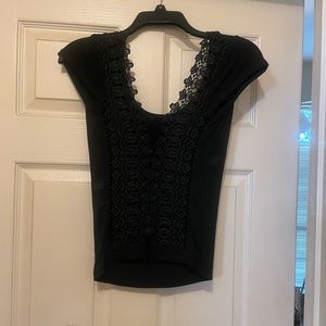 Black scoop neck top with lace insert and tie in the back. Delicate; hand wash.